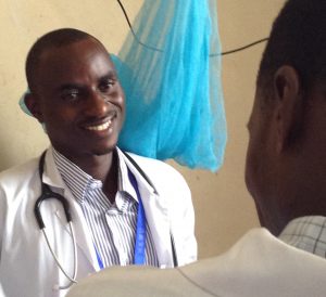Dr. Warles Charles Lwabukuna speaking with a colleague