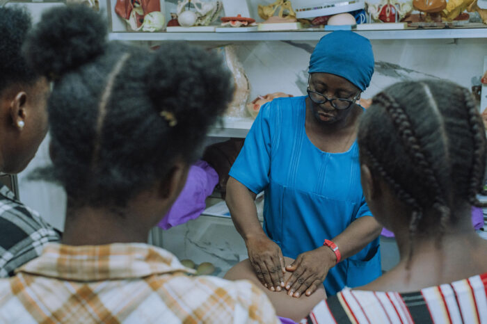 Sister Fatmata Daboh (in blue) demonstrates a procedure to midwifery students in the skills laboratory at SOMBO.