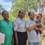 From left: Brenda (midwifery student) with Seed Educators Dr. Florence and Dr. Winnie, holding Susan’s baby.