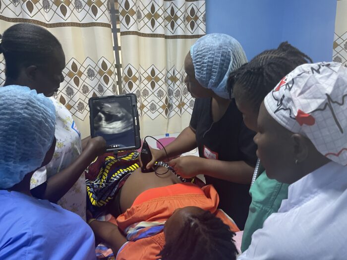 Midwives practice using the point-of-care ultrasound (POCUS) devises during the training session.