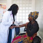 Dr. Winnie Mukelabai, a 4th year Family Medicine doctor, interacts with a patient at Chilenje Level One Hospital. Family Medicine doctors deliver comprehensive care across all stages of life, strengthening primary healthcare at the community level.